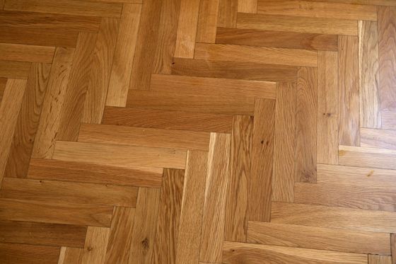 Gros plan sur un sol en parquet massif clair dans une pièce intérieure