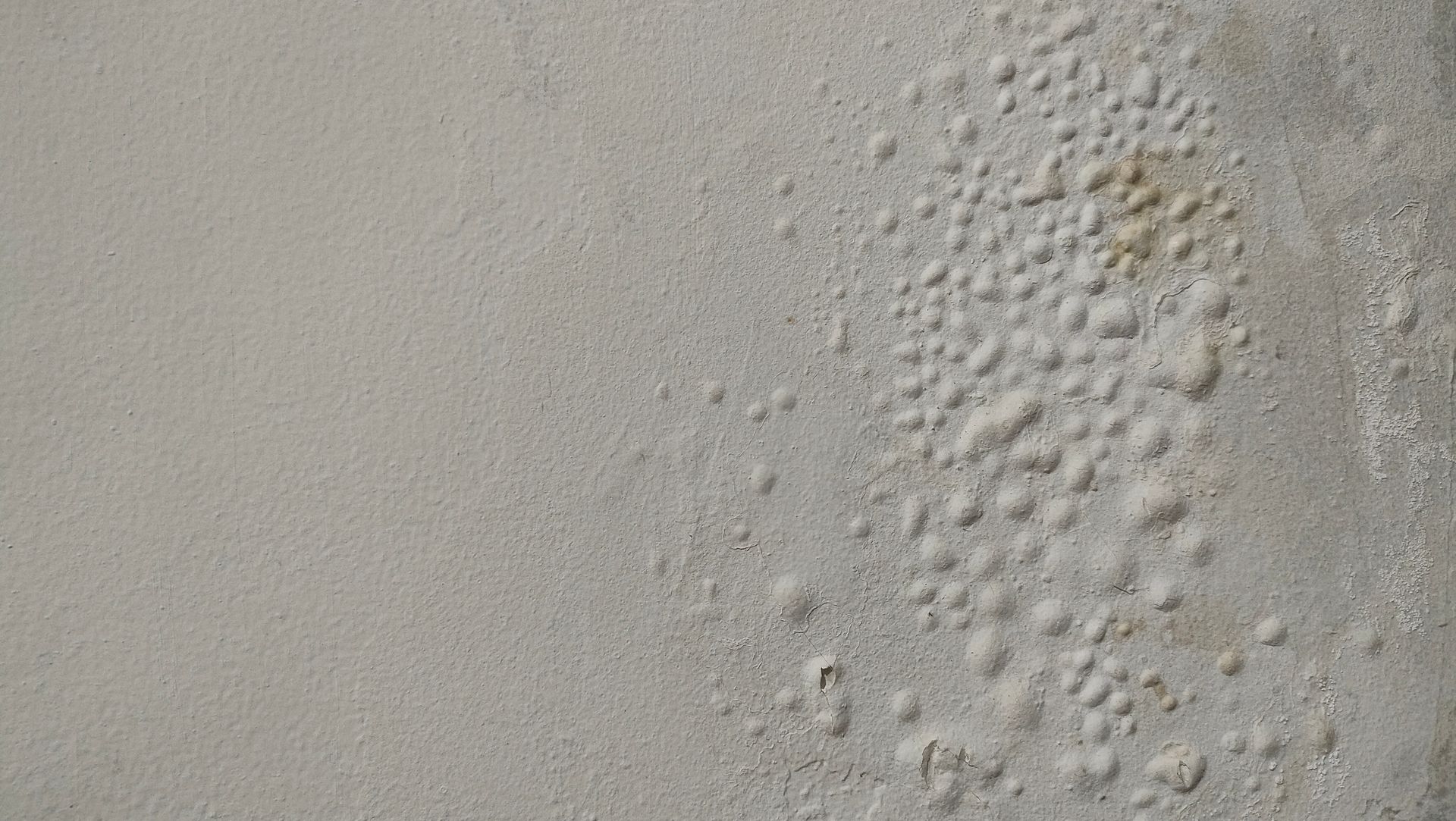 Mur extérieur avec marques d'humidité, tâches et déformations multiples