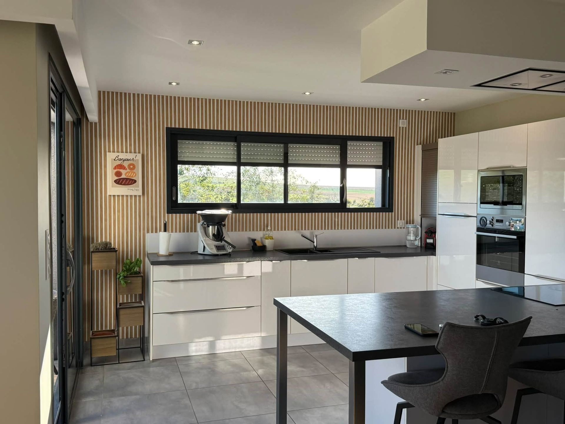 Cuisine moderne avec fenêtre et revâtement de mur en tasseaux de bois