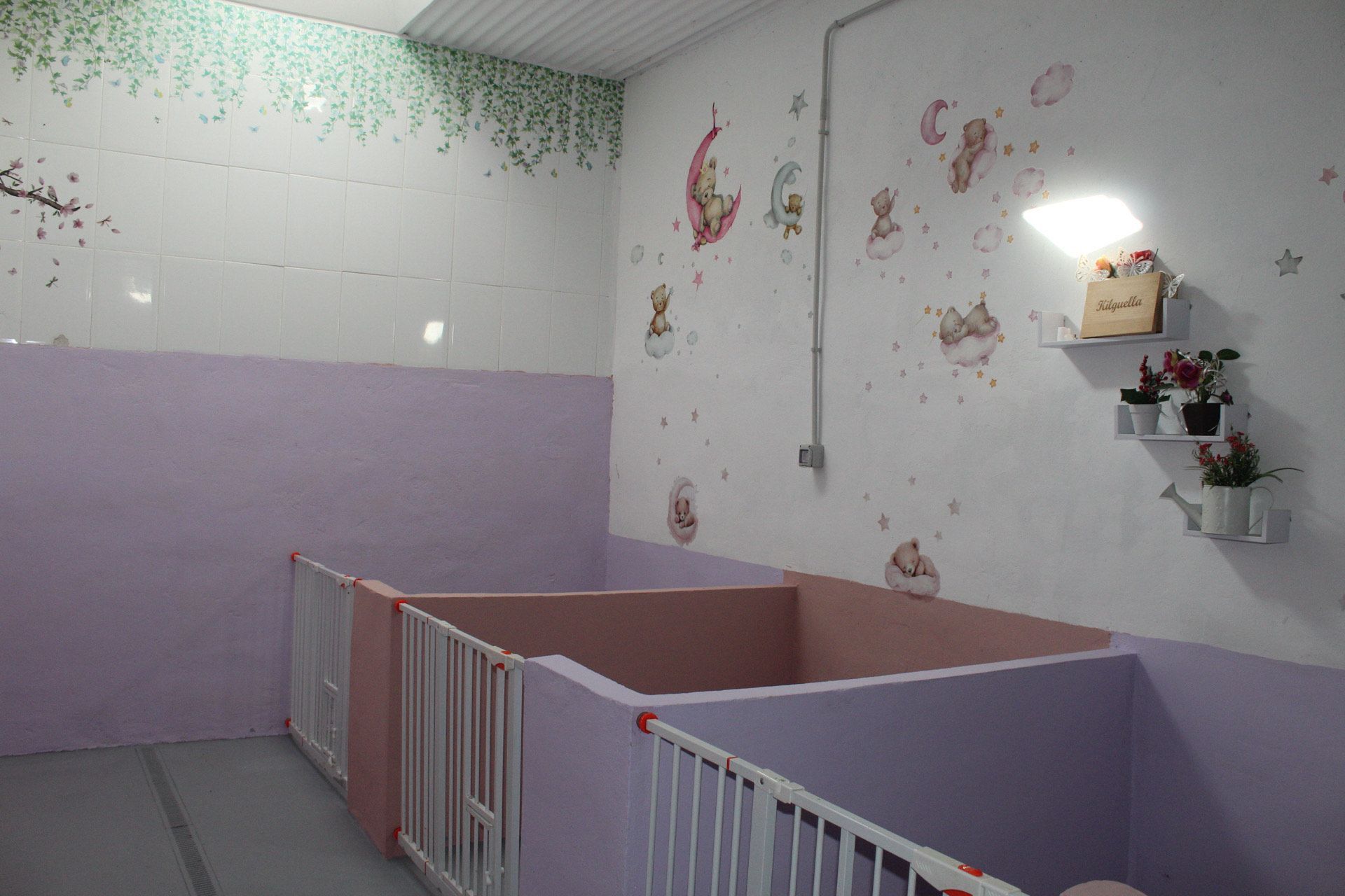 Una habitación infantil con cunas y decoración de pared con ositos de dibujos animados y lunas.