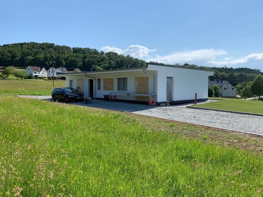 Ein weißes Haus steht inmitten einer Wiese.