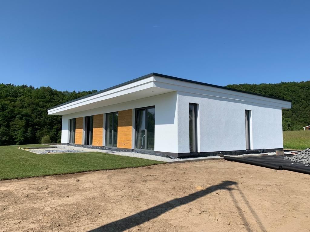 Ein kleines weißes Haus steht auf einem Feld.