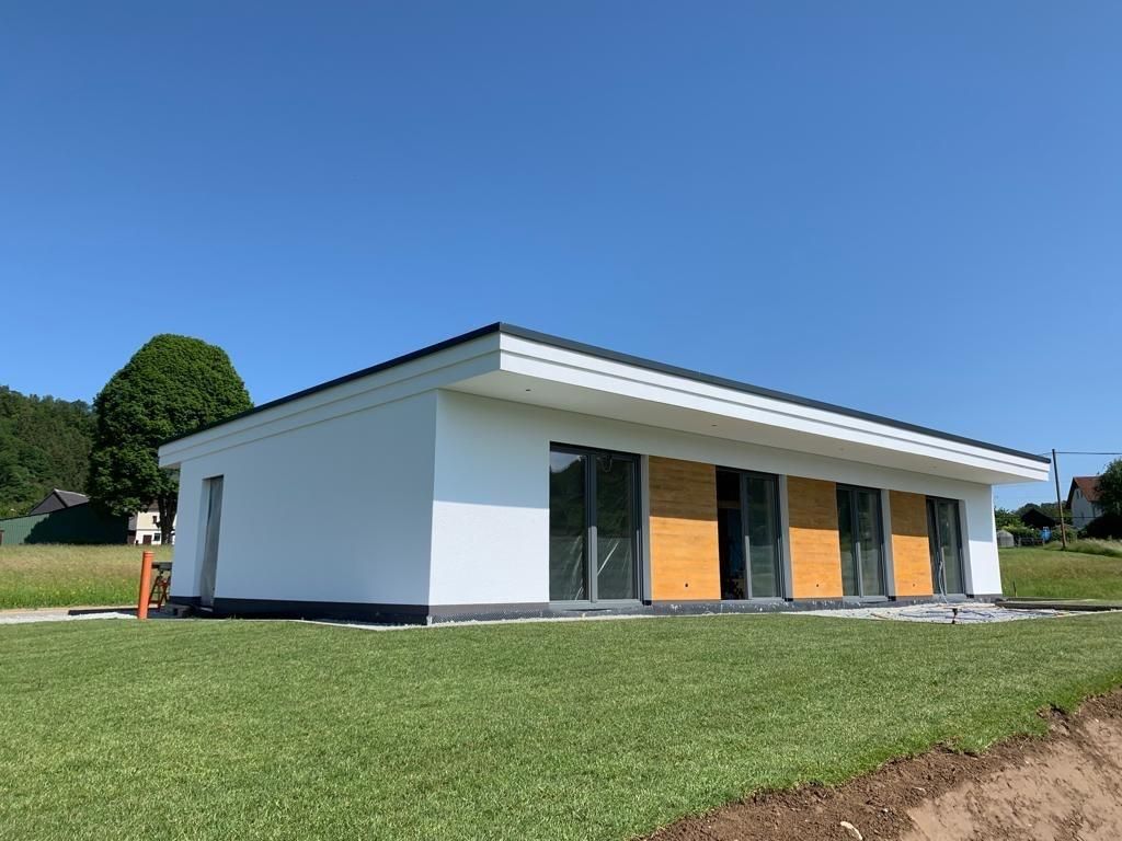 Ein kleines weißes Haus steht auf einem üppigen grünen Feld.