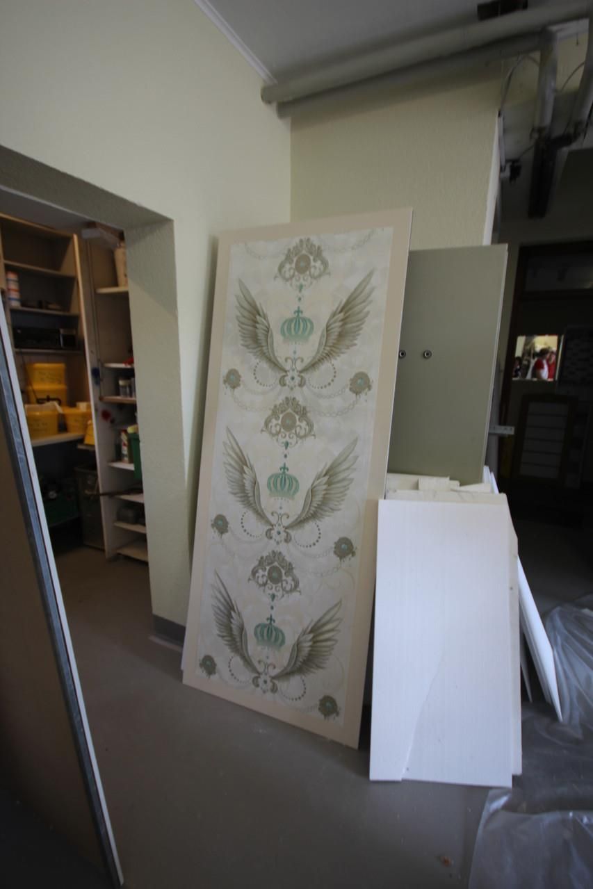 Ein großes Stück Papier mit Flügeln und Kronen darauf