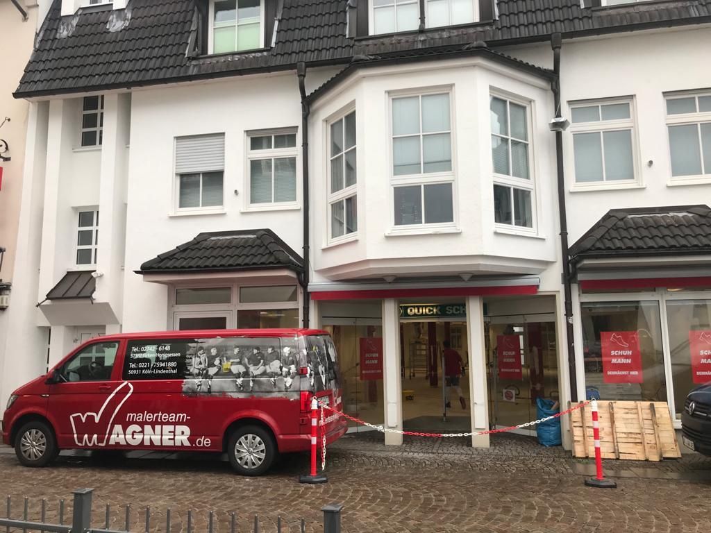 Ein roter Lieferwagen mit dem Wort Wagner auf der Seite steht vor einem Gebäude.