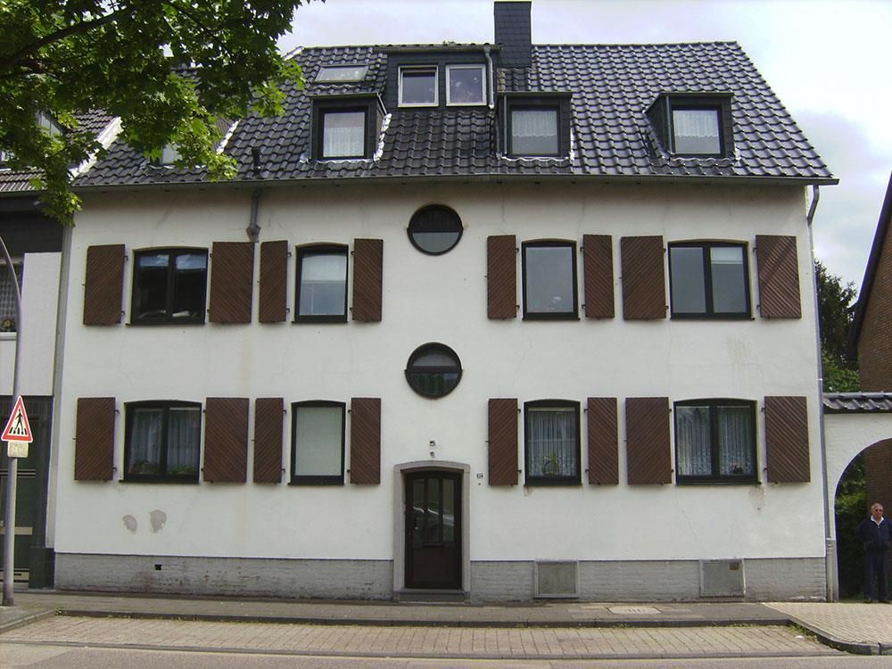 Ein weißes Gebäude mit braunen Fensterläden