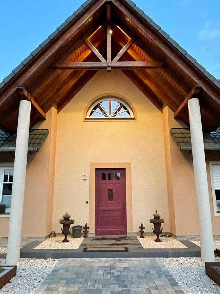 Ein Haus mit einer lila Tür und einem Holzdach