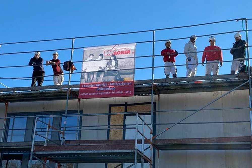 Eine Gruppe von Bauarbeitern steht auf einem Gerüst