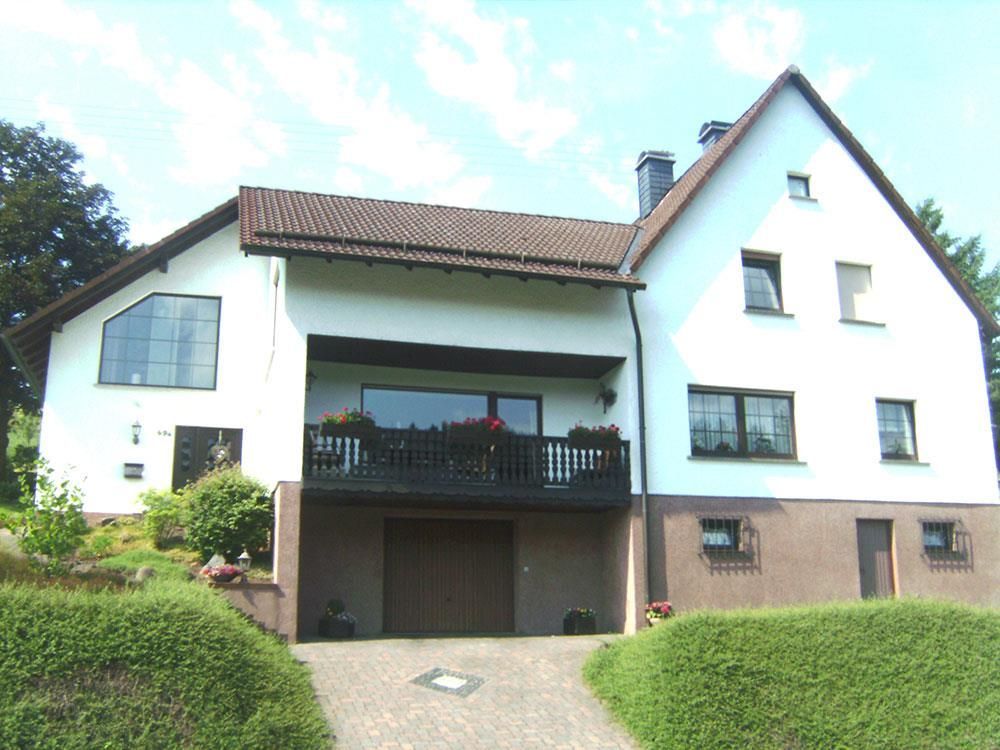 Ein großes weißes Haus mit einem braunen Dach