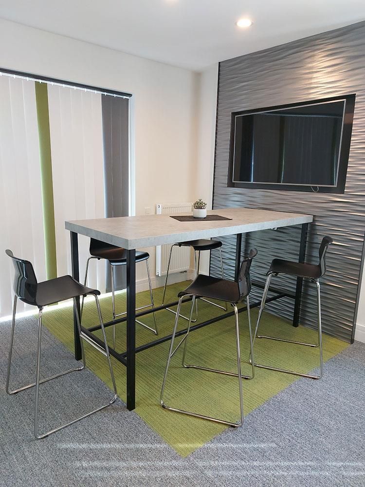 Ein Raum mit einem Tisch und Stühlen und einem Fernseher an der Wand.