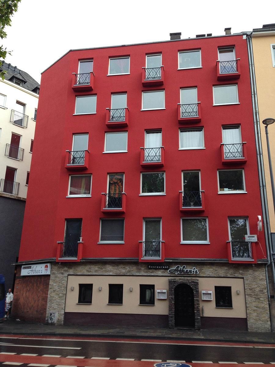 Ein rotes Gebäude mit vielen Fenstern und Balkonen