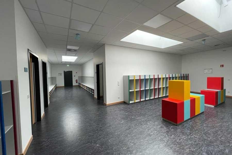 Ein Flur mit vielen Regalen und Stühlen darin