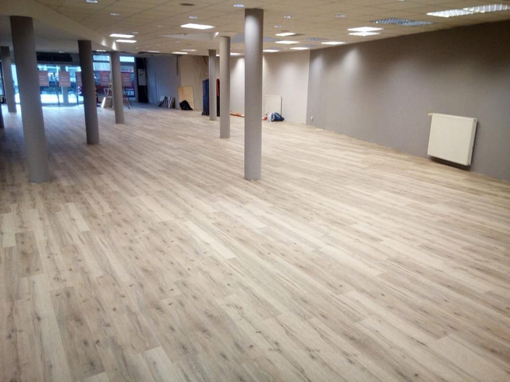 Ein großer leerer Raum mit Holzböden und Säulen