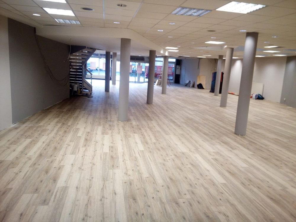 Ein großer Raum mit Holzboden und Säulen