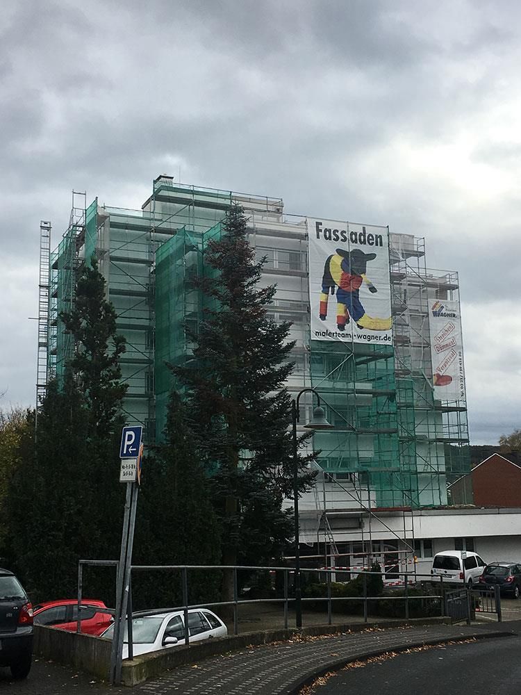 Ein Gebäude mit Gerüsten und einem Schild mit der Aufschrift „Fassadan“