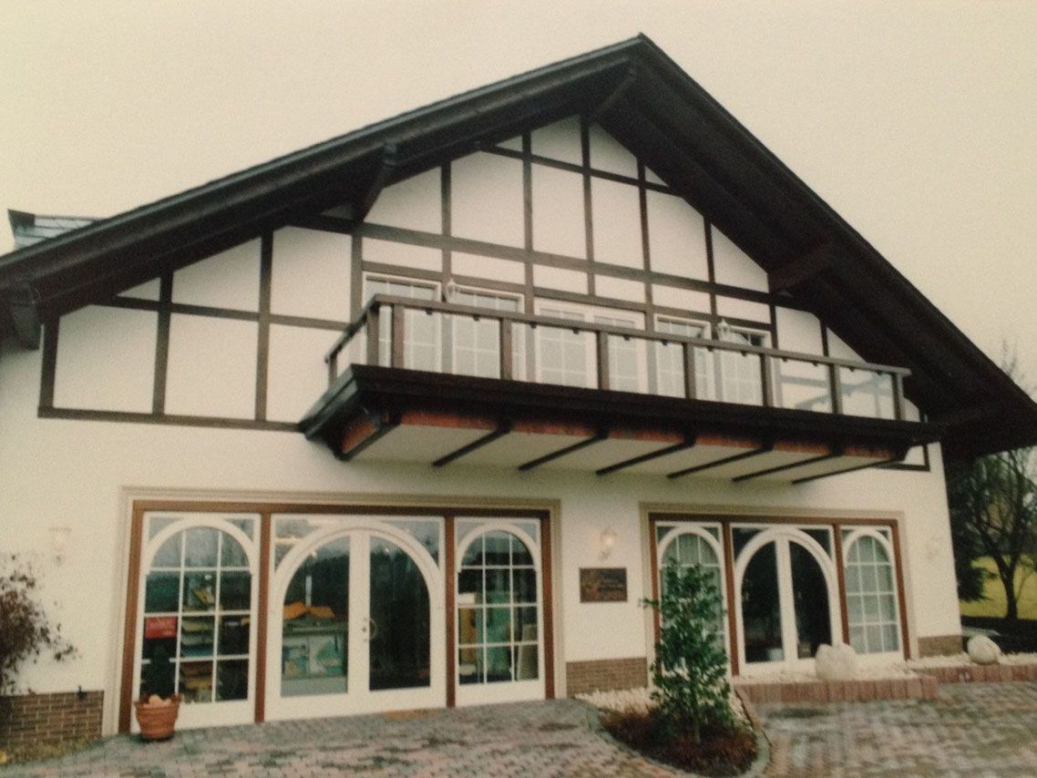 Ein großes Haus mit Balkon und vielen Fenstern