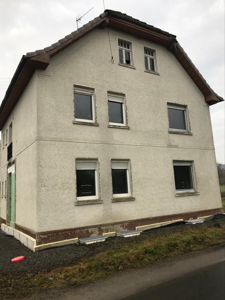 Am Straßenrand steht ein Haus mit vielen Fenstern.