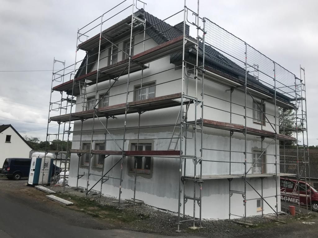 Es wird ein Haus mit Gerüst darum herum gebaut.