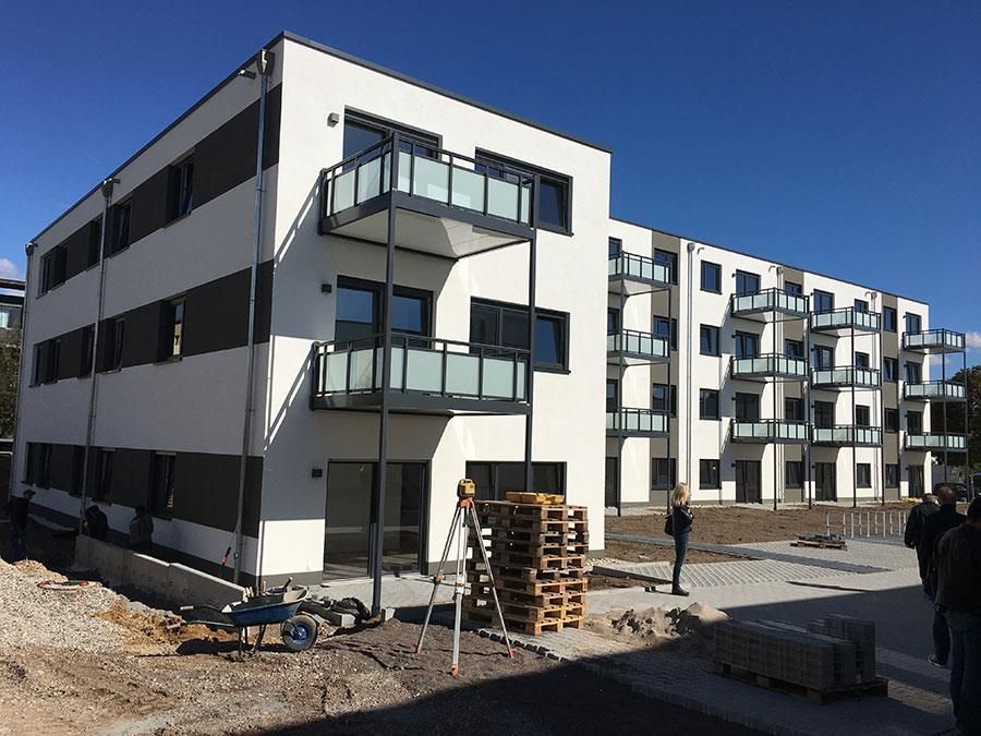Ein großes weißes Gebäude mit Balkonen und einem blauen Himmel im Hintergrund