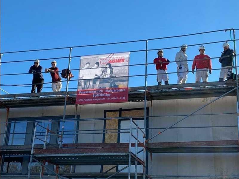 Eine Gruppe von Bauarbeitern steht auf einem Gerüst