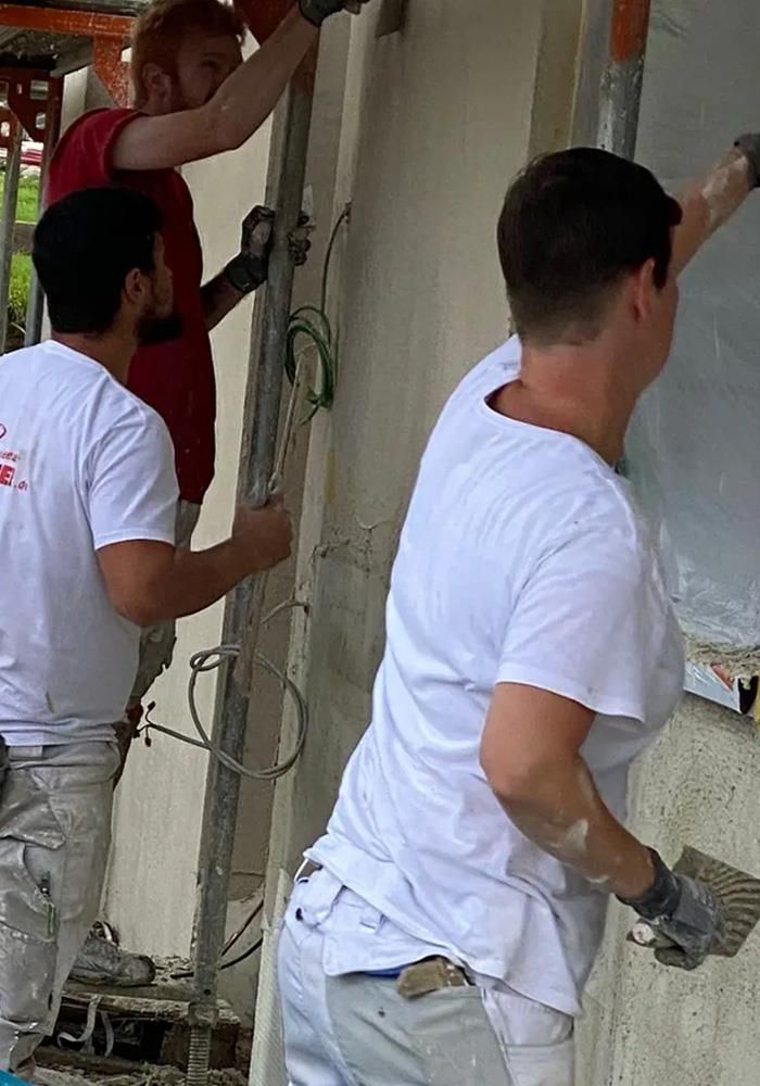 Eine Gruppe Männer arbeitet an einem Gebäude.