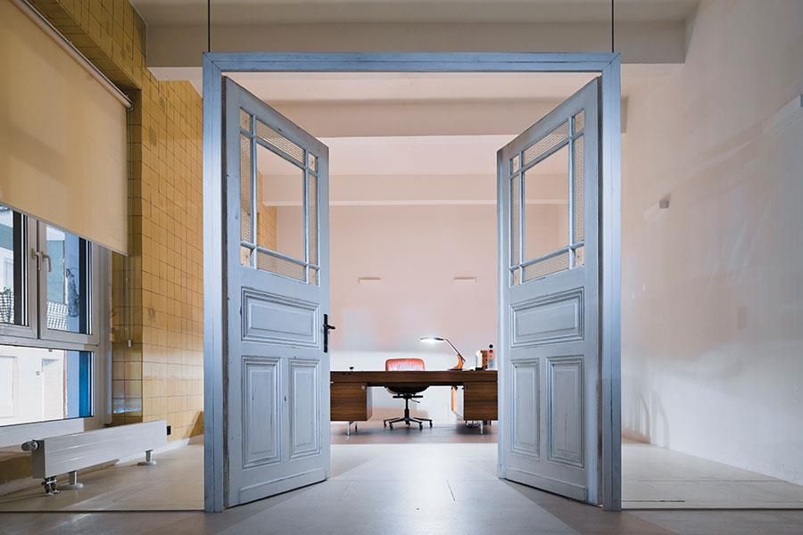 Die Türen öffnen sich zu einem Raum mit einem Schreibtisch und einem Stuhl.