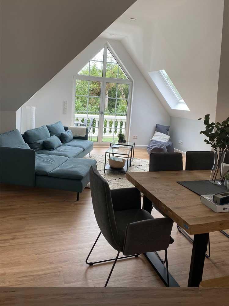 Ein Wohnzimmer mit einer blauen Couch und einem Holztisch