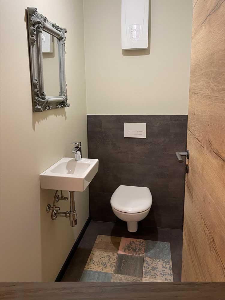 Ein Badezimmer mit Toilette, Waschbecken und Spiegel.