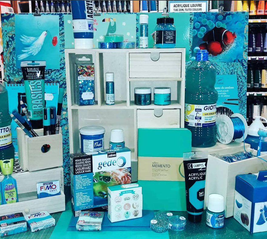 Présentation de matériel artistique dans différentes nuances de bleu et de turquoise.