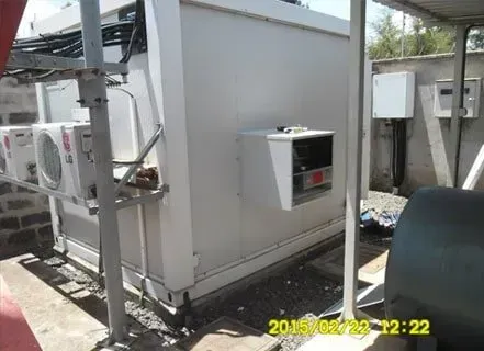 A white building with a lot of wires coming out of it.