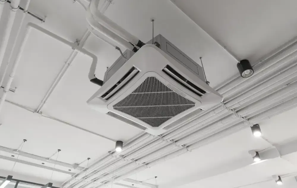 A black and white photo of a ceiling mounted air conditioner.