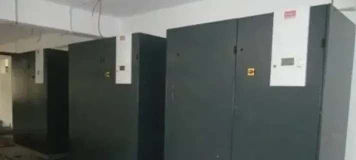 A row of black cabinets are lined up in a room.