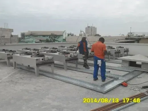 Two men are working on the roof of a building 