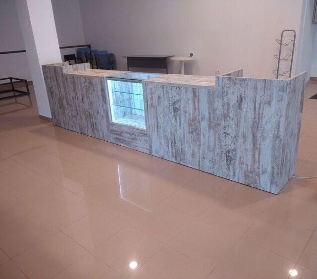 Un largo mostrador de madera con una vitrina de cristal en una habitación.