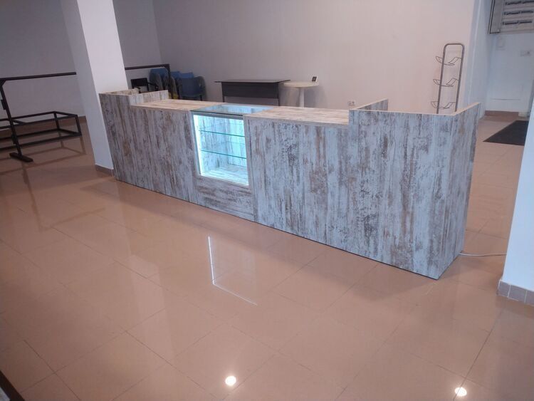 Un largo mostrador de madera con una vitrina de cristal en una habitación.