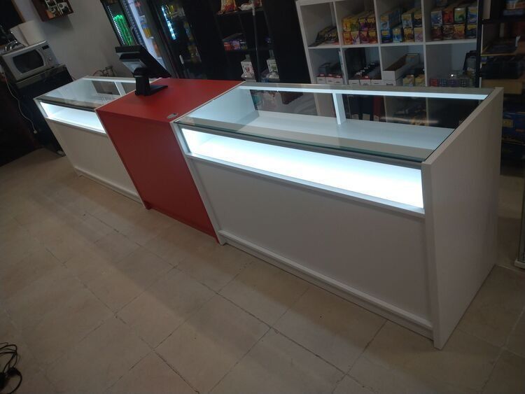 Un mostrador rojo y blanco con una vitrina de cristal en una tienda.