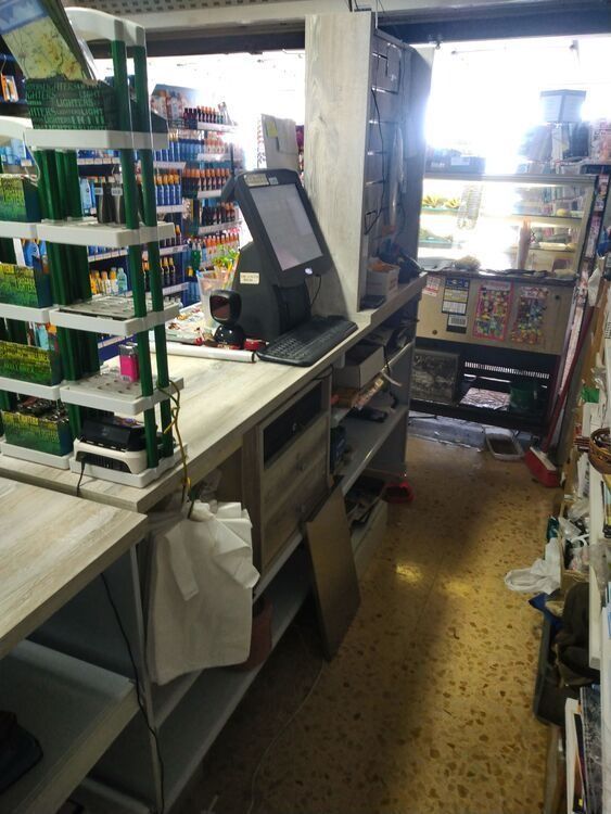 Una tienda con estantes y una computadora en el mostrador.