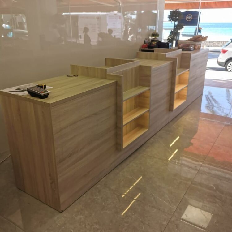 Un largo mostrador de madera con estantes en una tienda.