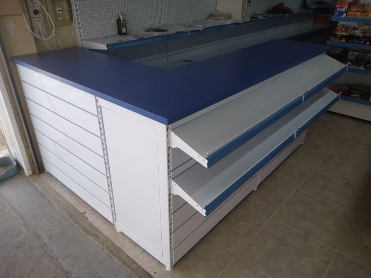 Un mostrador azul y blanco con estantes en una tienda.