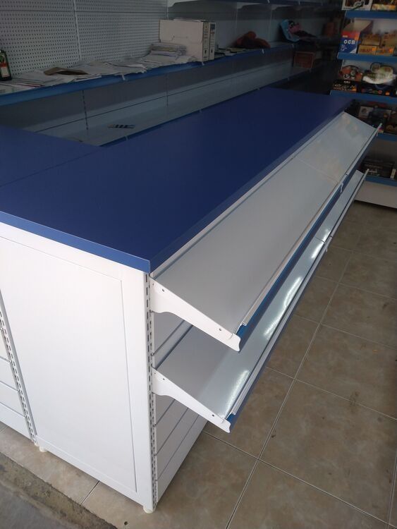 Un mostrador azul y blanco con estantes en una tienda.