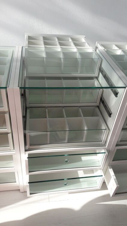 Un armario con muchos cajones y estantes de cristal.