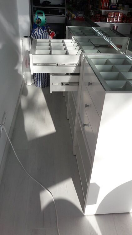 Una fila de cajones blancos con tapas de cristal en una tienda.