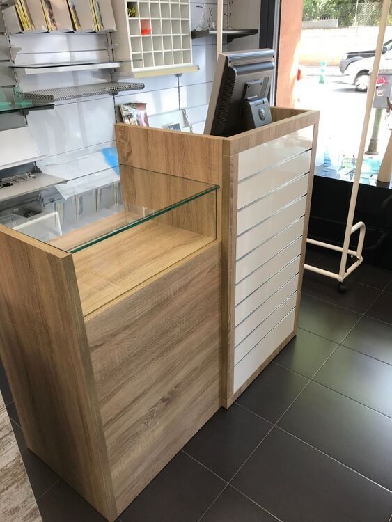 Un mostrador de madera con tapa de cristal en una tienda.