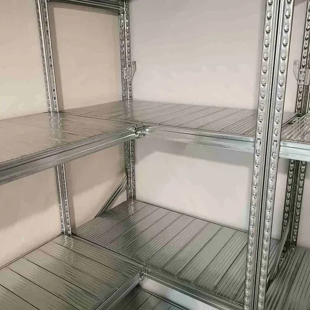 Una fila de estantes de metal en una habitación con una pared blanca.