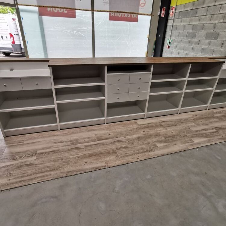 Un estante largo con cajones y estantes en una tienda.