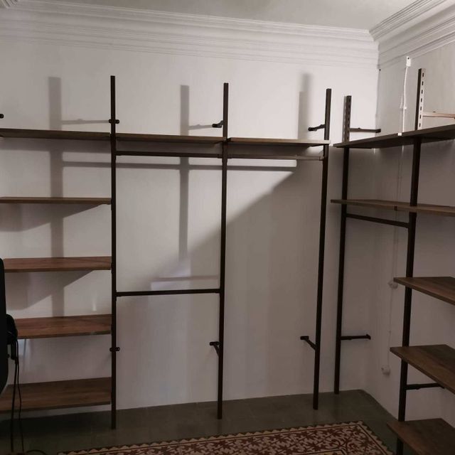Un armario con muchos estantes y percheros.