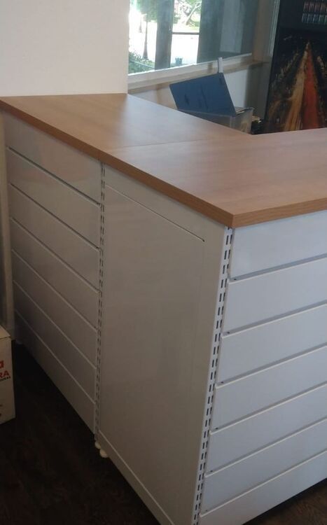 Un mostrador blanco con tapa de madera en una habitación.