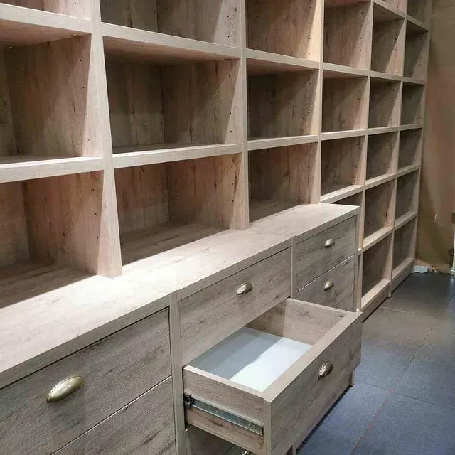 Una habitación con muchos estantes y cajones con un cajón abierto.