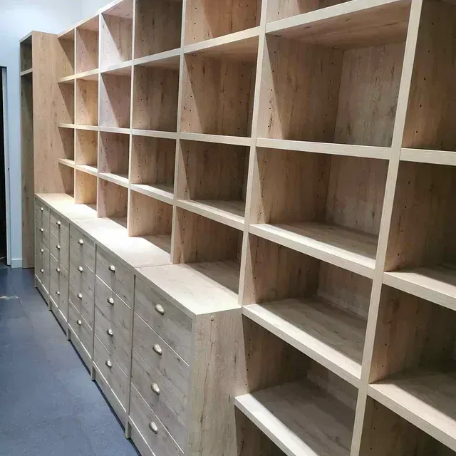 Una fila de estantes y cajones de madera en una habitación.