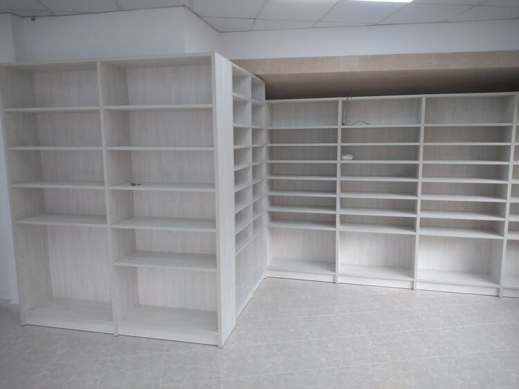 Una habitación con muchos estantes y una luz de techo.